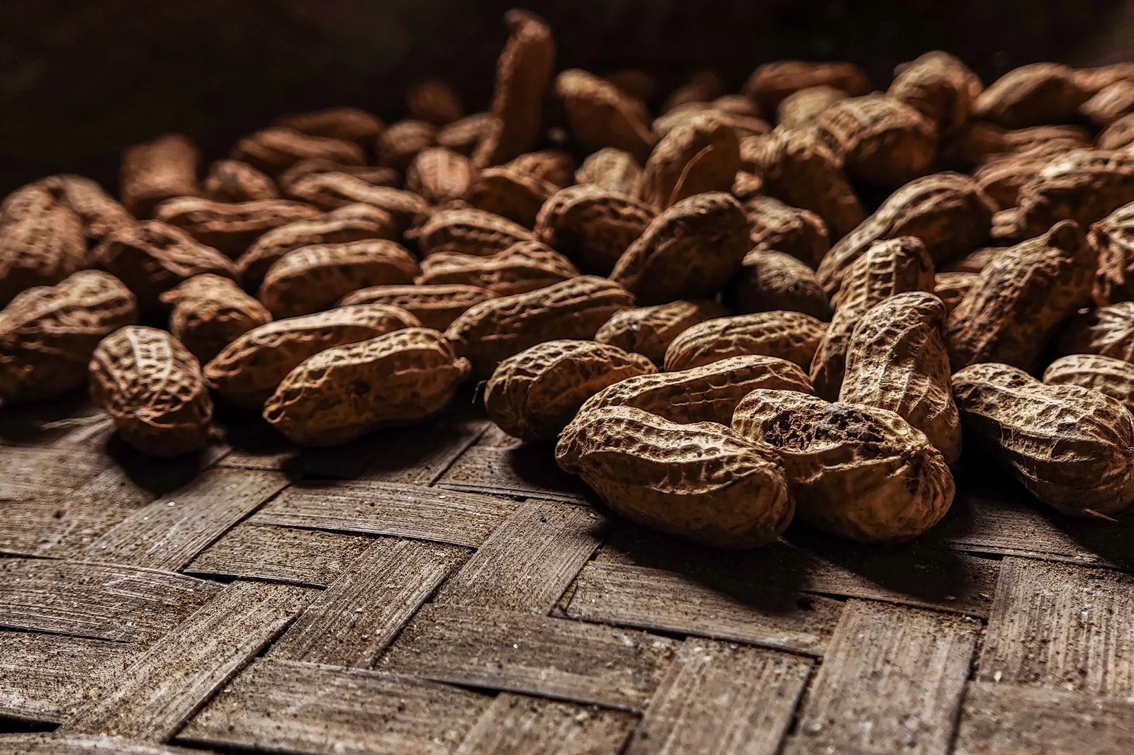 In-shell peanuts on dark wood